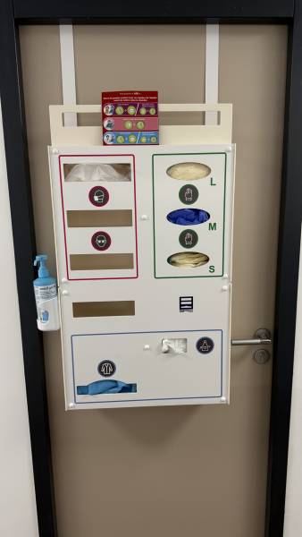 distributeur precobox maxima 9 epi fixé sur porte avec système de bretelles, chargé en équipements de protection individuelle